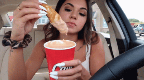 Woman in Car Eating Pizza and Drinking Caffe