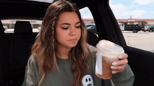 Woman in Car Holding Coffee Cup With Big O Logo