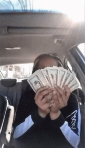 Woman in Car Holding Money