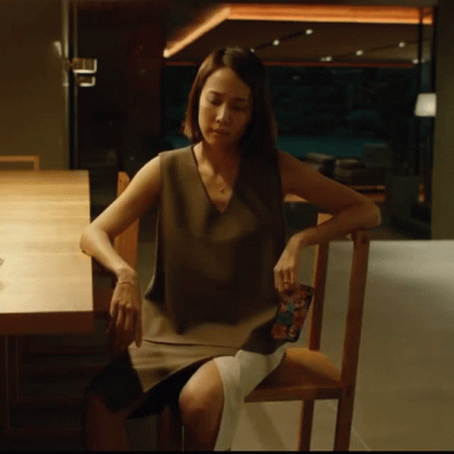 Woman In Chair Looking Down GIF