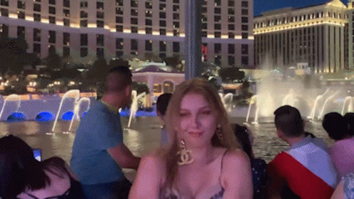 Woman in Chanel Earrings by Fountain at Night