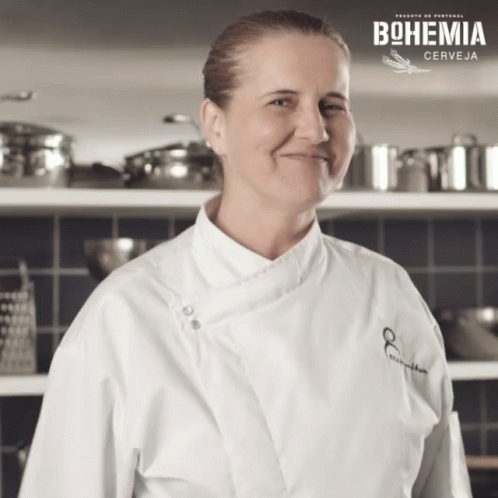 Woman In Chef's Coat Smiling In Front Of Bohemia Sign