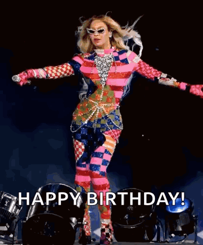Woman in Colorful Outfit on Stage With Arms Outstretched