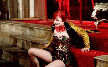 Woman In Corset And Gold Jacket On Red Carpet GIF