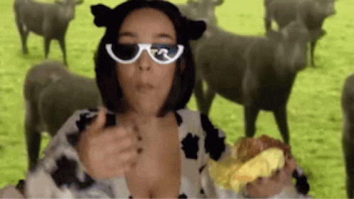 Woman In Cow Costume Holding Hamburger Before Sheep GIF