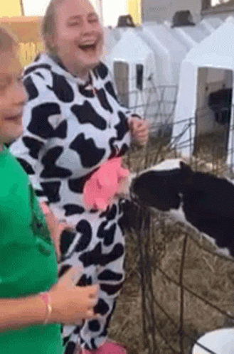 Woman In Cow Print Costume Next To Baby Cow GIF