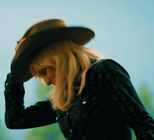 Woman in Cowboy Hat and Black Shirt Looking Down