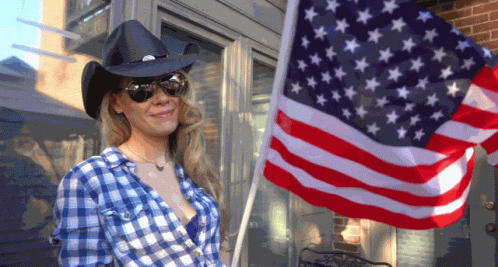 Woman in Cowboy Hat and Plaid Shirt Holding American Flag