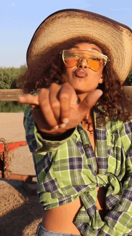 Woman in Cowboy Hat and Sunglasses Pointing