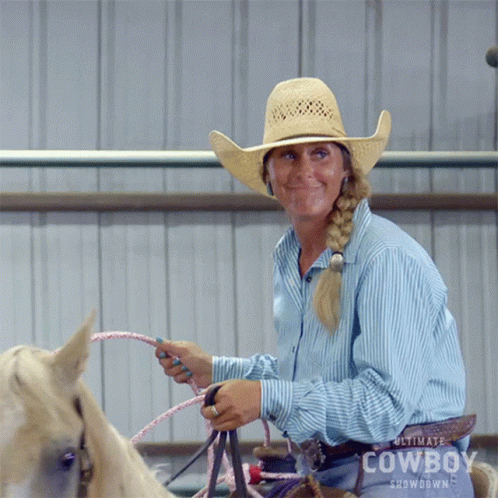 Woman in Cowboy Hat Riding Horse with Rope