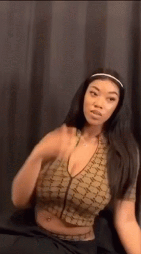 Woman In Crop Top And Headband Sitting On Bed GIF