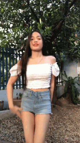 Woman In Crop Top And Shorts Arms Outstretched On Beach GIF