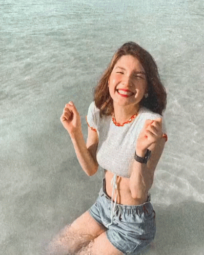 Woman In Crop Top And Shorts Kneeling In Water GIF