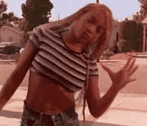 Woman In Crop Top And Shorts On Sidewalk GIF