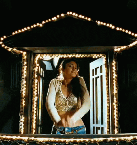Woman In Crop Top Standing In Window With Lights GIF