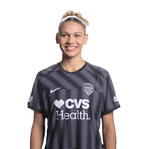 Woman in CVS Health Shirt Smiling With Hands Folded