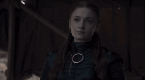 Woman In Dark Room Wearing Necklace With Circle GIF