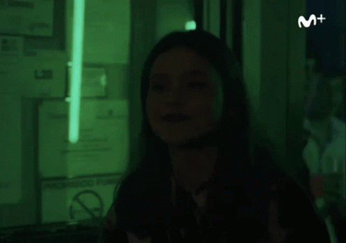 Woman in Dark Room With Green Light and No Smoking Sign