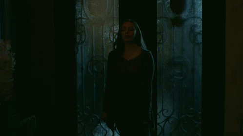 Woman In Dark Room With Wrought Iron Door GIF