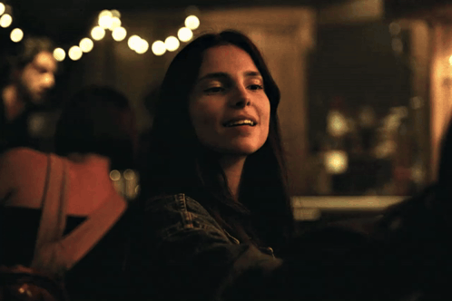 Woman in Denim Jacket Sitting in Dark Room