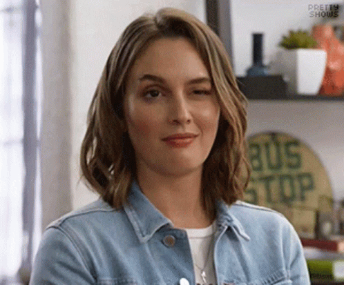 Woman In Denim Jacket Smiling And Winking GIF