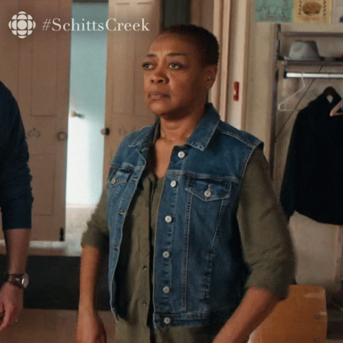 Woman In Denim Vest At Schitts Creek Door GIF
