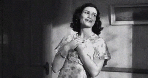 Woman in Dress Standing with Hands on Chest