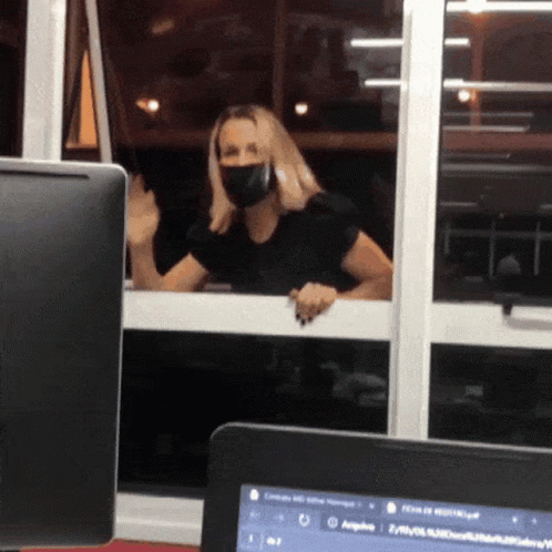 Woman in Face Mask Looking Out Window