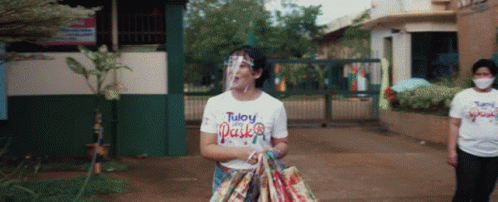 Woman in Face Shield and White Tuloy Pasko Shirt