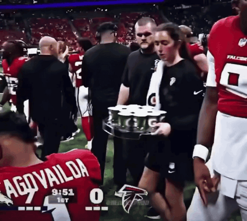 Woman In Falcons Jersey Carrying Tray Of Drinks GIF