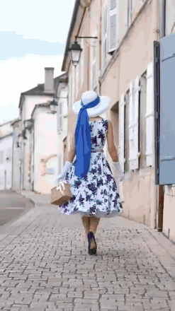 Woman in Floral Dress and White Hat Walking
