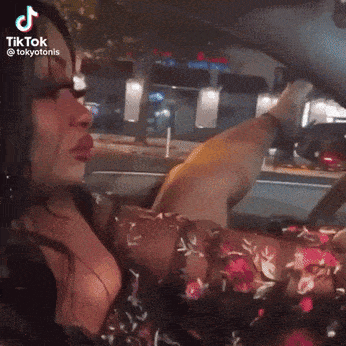 Woman in Floral Dress Driving Car With TikTok Account