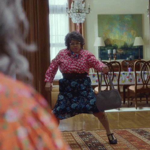 Woman In Floral Dress Holding Purse GIF
