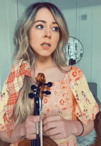 Woman in Floral Dress Holding Violin