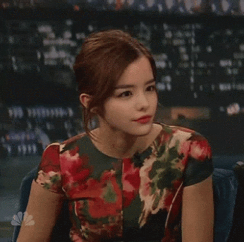 Woman In Floral Dress Sitting At Microphone GIF