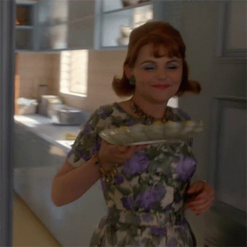 Woman in Floral Dress Smiling Holding Plate