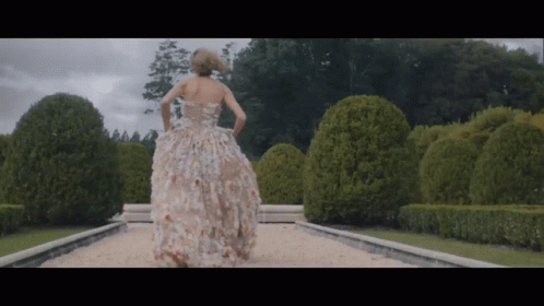 Woman in Floral Dress Walking Down Path