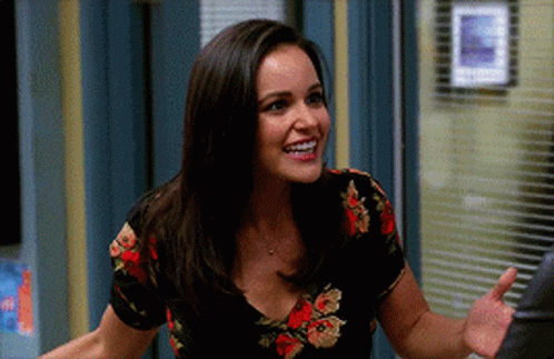 Woman In Floral Shirt Smiling And Waving Hand GIF
