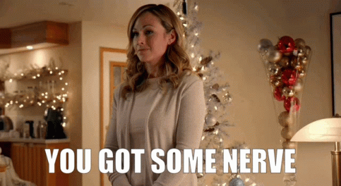 Woman In Front Of Christmas Tree Saying You Got Some Nerve GIF