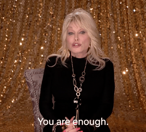 Woman in Front of Gold Sequined Wall Says You Are Enough
