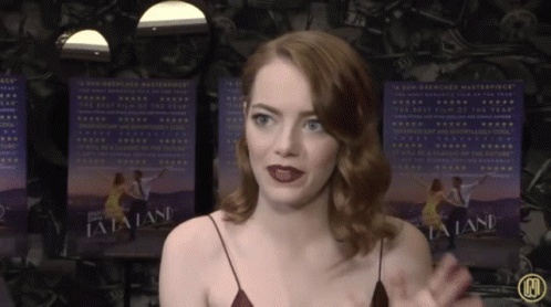 Woman In Front Of La La Land Posters GIF