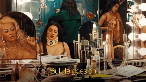 Woman in Front of Mirror Saying But Life Goes On
