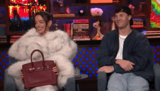 Woman in Fur Coat Holding Red Handbag Beside Man