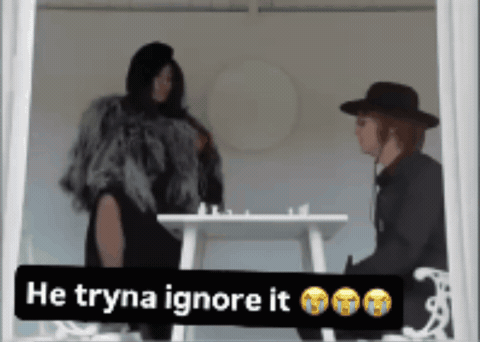 Woman in Fur Coat Next to Man in Black Hat Saying He Tryna Ignore It