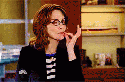 Woman in Glasses and Black Jacket With NBC on Sleeve