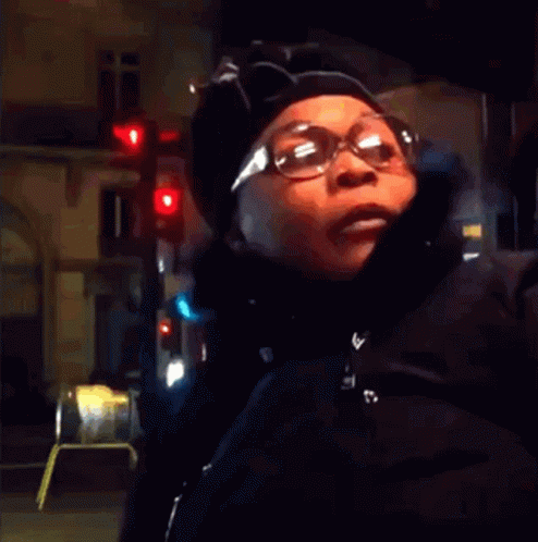 Woman in Glasses and Hat at Red Light