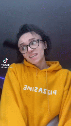 Woman In Glasses And Yellow Hoodie With TikTok Icon GIF