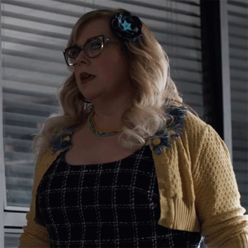 Woman in Glasses and Yellow Sweater in Front of Window