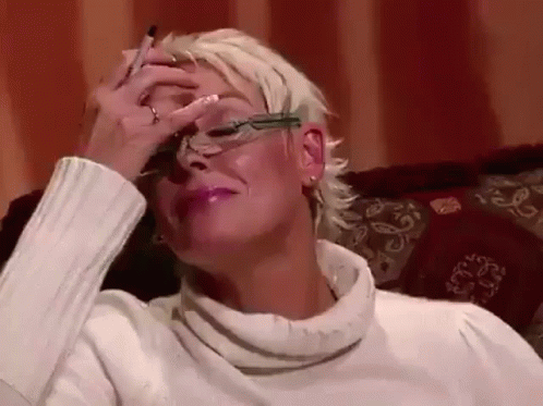 Woman in Glasses Covering Face on Couch