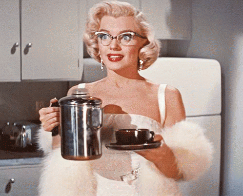Woman in Glasses Holding Coffee Pot and Cup of Coffee
